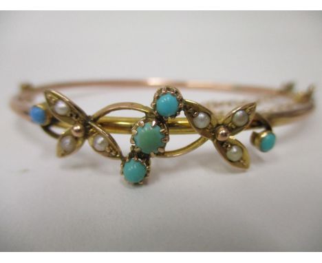 An Edwardian gold coloured metal bangle set with turquoise and seed pearls in the form of two flowers, 5.5g, total 