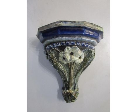 A Martin Bros stoneware wall bracket by Robert Wallace Martin naturalistically modelled with flowers and leaves in shades of 