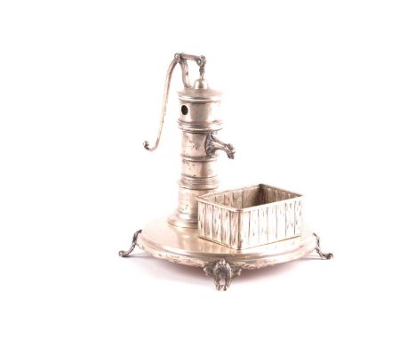 A Continental white metal novelty cheroot cutter, possibly German, modelled as a hand cranked water pump, with rectangular si