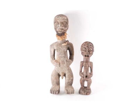 A Songye standing male reliquary power figure, Democratic Republic of Congo, the crown of the head with vacant aperture, the 