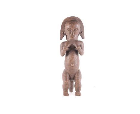 A Fang female reliquary figure, Gabon, the coiffure almost carved as a cowl, her hands placed upon her breasts, the elongated