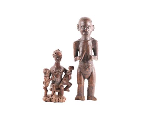 A Baule maternity figure, Ivory Coast, the smiling figure seated upon a stool and holding onto two large infants, 31.5cm; tog