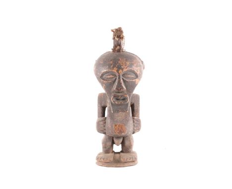 A Songye standing male power figure, Nkisi, Democratic Republic of Congo, the large head with central horn charge adorned wit