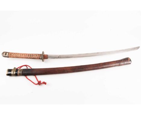 A WW II Japanese Shin Gunto Katana with spring steel blade cast brass tsuba and a cord lashed faux ray skin grip. In a leathe