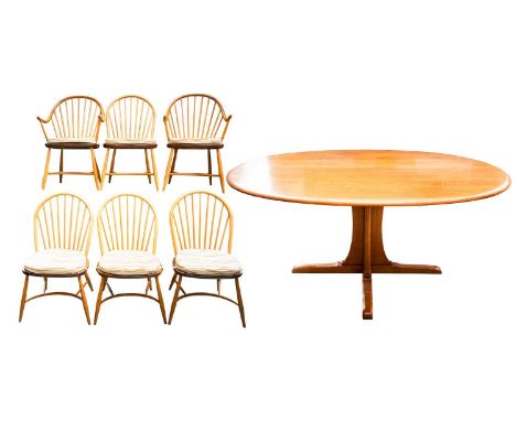 An Ercol golden dawn light elm oval dining table and six "Windsor" style dining chairs comprising two hoop backed carvers and