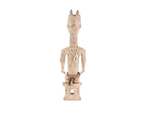 A large Bantu seated female figure, Nigeria, a coiffure of four Bantu knots, with scarification pegs embedded throughout the 