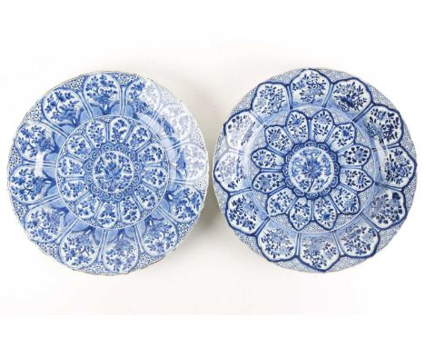 A pair of Chinese blue & white chargers, Kangxi, early 18th century, painted with radiating panels of blossoming flowers arou