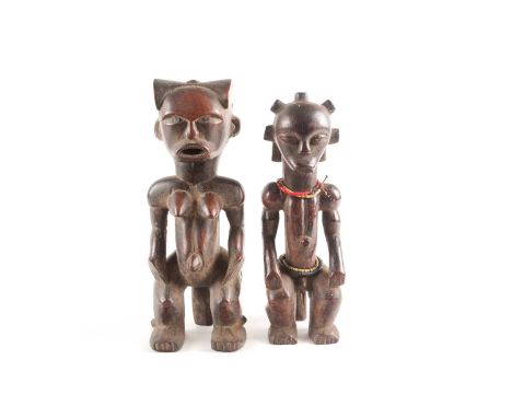 A Fang seated male figure, Gabon, with knotted hair swept out at the rear, seated with his hands upon his knees and with a pr