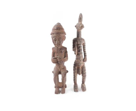 A Bobo/Koro standing warrior figure, Burkina Faso, with crescent shaped headdress, the body carved as square scales, with pro