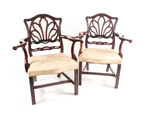 A pair of probably American "Chippendale Style" mahogany open arm elbow chairs with a laurel branch and wreath carved crestin