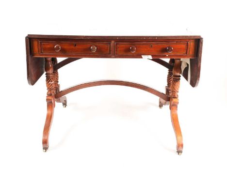 A Regency brass inlaid mahogany two flap sofa table. Fitted two frieze drawers. On "Solomonic" column end supports and invert