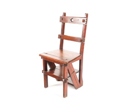 A Victorian golden oak gothic style folding metamorphic chair/ library steps, with pierced cresting rail above a solid seat. 
