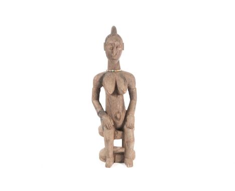 A Baule seated maternity figure, Ivory Coast, with linear and chevron coiffure, scarifications either side of her eyes and ar