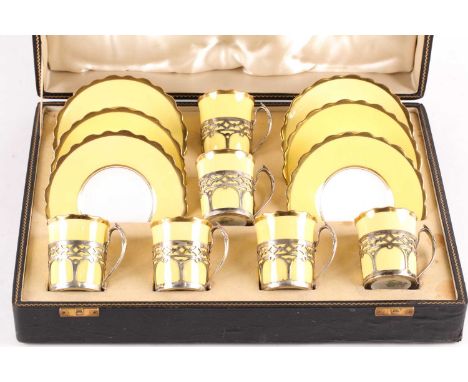 A set of six Aynsley bone china silver-mounted coffee cans and saucers, the two-tone yellow and gilt-edged china with silver 