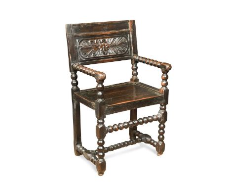 A Flemish oak bobbin turned armchair, late 17th century, the rectangular back with flower and leaf carved panel between bobbi