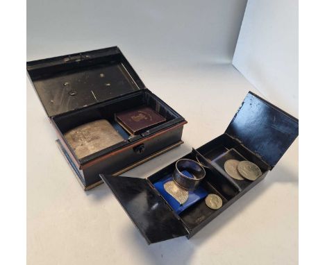 A metal money box containing a small collection of coins, together with a silver napkin ring, a silver cigarette case and a g