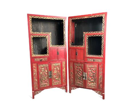 A pair of Chinese carved wood red lacquer and parcel-gilt display cabinets, late Qing Dynasty, the upper section with three d