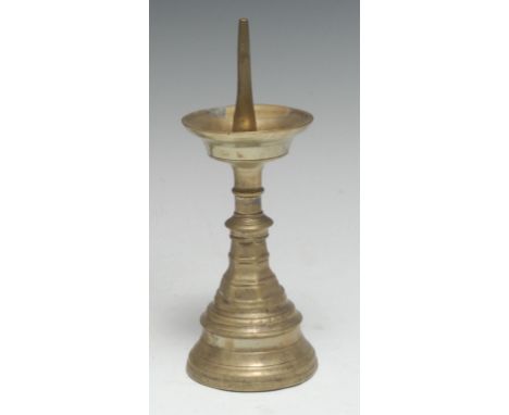 A 16th century brass pricket candlestick, dished wax pan, knopped stem with spreading hexagonal socle, waisted circular base,