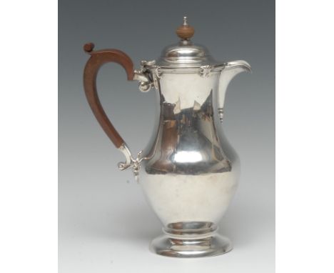 A George V silver baluster hot water pot, hinged domed cover, scroll-capped handle, domed foot, 23cm high, Birmingham 1924, 1