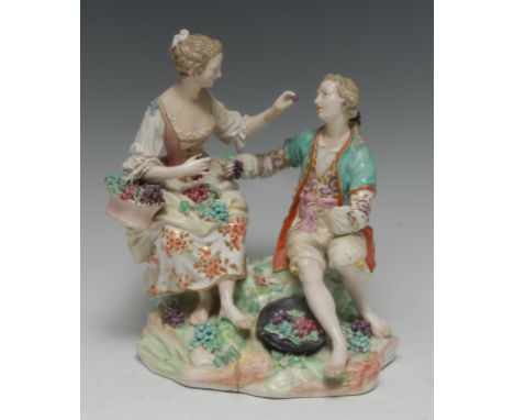 A Derby Patch Mark figure group, of a courting couple, both in fancy dress, she with basket of grapes and feeding her compani