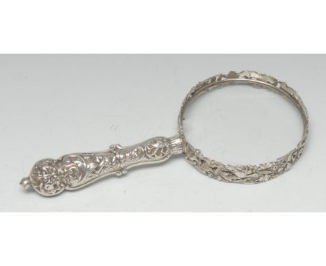 A Victorian silver magnifying glass, the bezel cast with fanciful birds and putti amongst flowering scrolling foliage, the em