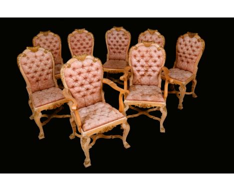 A set of eight Baroque Revival parcel-gilt dining chairs, shaped arched backs, deep-buttoned upholstery, carved throughout wi