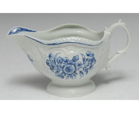 A Worcester blue and white sauce boat, crisply moulded with overlapping scales painted with flowers in three panels, the inte