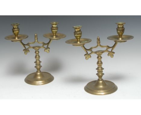 A pair of 19th century brass two-light table candelabra, urnular sconces, broad dished drip pans, knopped pillars, domed circ