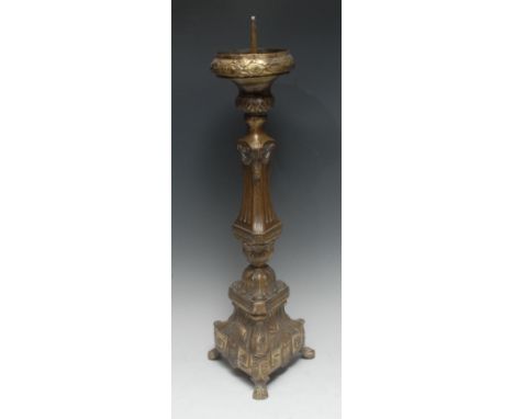 A 19th century Continental brass triform altar pricket candlestick, bowed drip pan with fruiting laurel border above a Baroqu