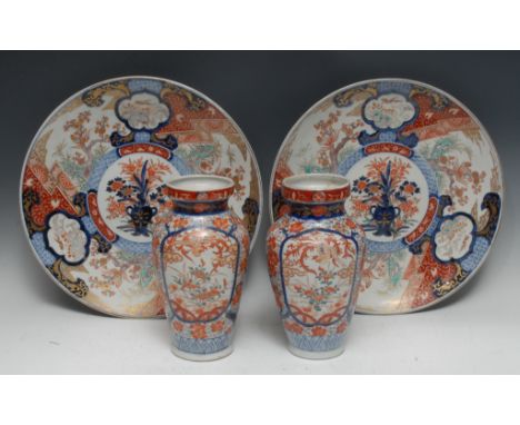 A pair of late 19th century Japanese Imari chargers, decorated in the typical palette with vase with issuing flowers within a