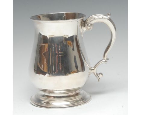 A George II silver bell shaped mug, quite plain, flared rim, acanthus capped double scroll handle, skirted base, 13cm high, R