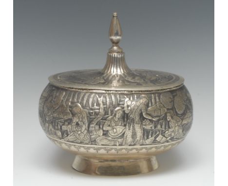 A Persian silver oval box and cover, profusely chased with busy figures in landscapes, steeple finial with lotus socle, skirt