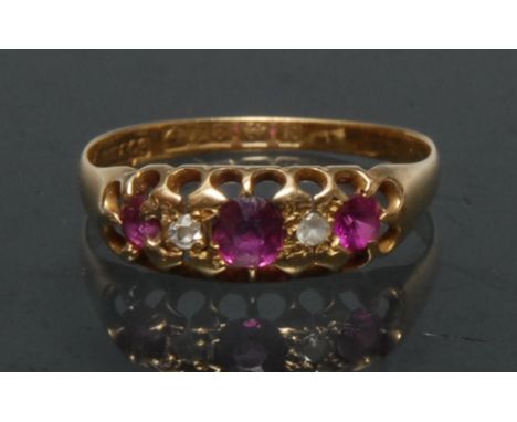 A diamond and pinky red ruby quintet line ring, inset with three graduated pale pinky red rubies, each divided by a diamond a