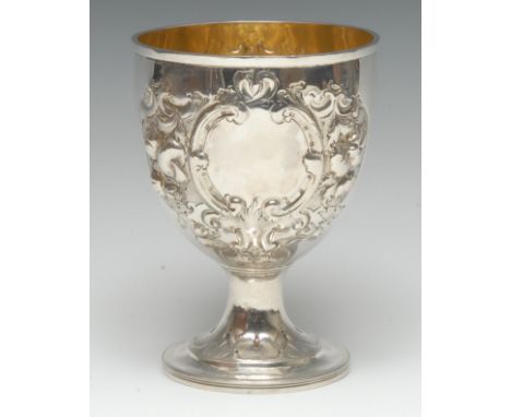 A large George IV silver pedestal goblet, chased with flowers and foliage within leafy C-scroll cartouches, domed foot, gilt 