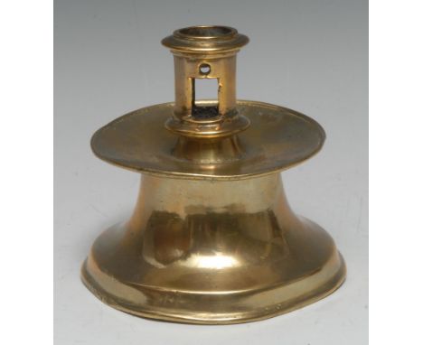 A 16th century Spanish brass capstan candlestick, pierced cylindrical sconce, broad slightly dished drip pan, trumpet shaped 