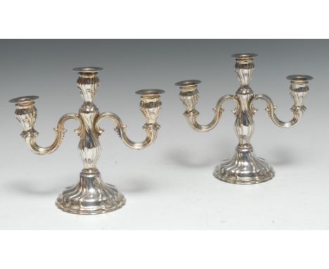 A pair of German silver three-light candelabra, fluted and embossed in the Rococo taste, 19.5cm high, sterling standard, Wilh