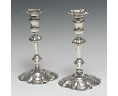 A pair of George II cast silver table candlesticks, of substantial gauge, fluted detachable nozzles, reel shaped sconces, kno