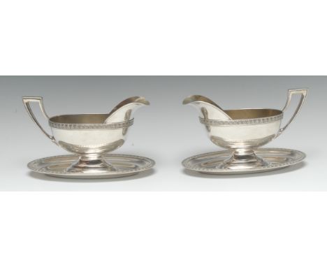 A pair of German silver sauce boats, angular scroll handles, integral stands, palmette borders, gilt interiors, 19cm long, ha