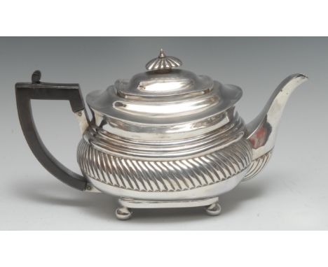 A George III silver boat shaped teapot, flush-hinged domed cover with fluted knop finial, above a broad gadrooned band, bun f