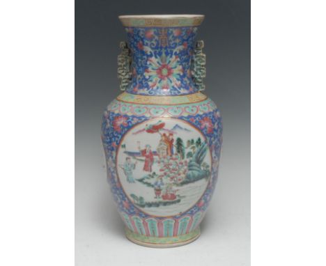 A Chinese Famille Rose temple vase, painted with circular cartouche figures and foliage, the sides with circular cartouches a