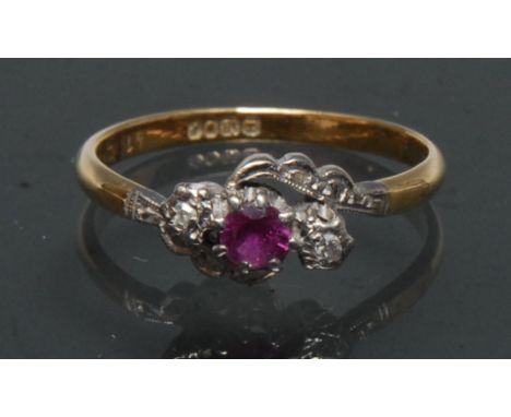 An Edwardian diamond and pinky red ruby trilogy twist ring, central round pinky red ruby, flanked by a small old brilliant cu