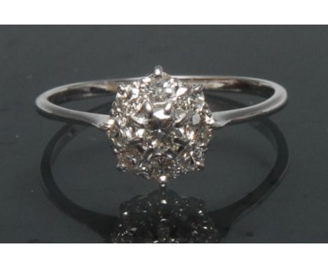 A diamond cluster ring, central round brilliant cut diamond, approx 0.20ct, surrounded by an collar of eight conforming small
