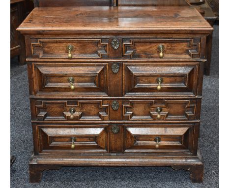 A Charles II oak block-front chest, rectangular moulded top above two short and three long drawers, applied with geometric mo