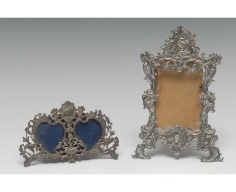 A late 19th century silver shaped rectangular easel photograph frame, embossed with putti and scrolling foliage, 16.5cm high,