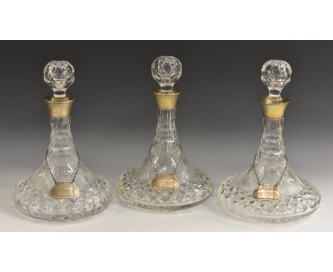 A set of three hobnail and strawberry cut ship's decanters, silver mounted, each on silver and draught turned stands, 30cm hi