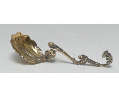 A Victorian Neo-Renaissance silver-gilt caddy spoon, shell shaped bowl, the haft cast with a kneeling satyr and griffin masks