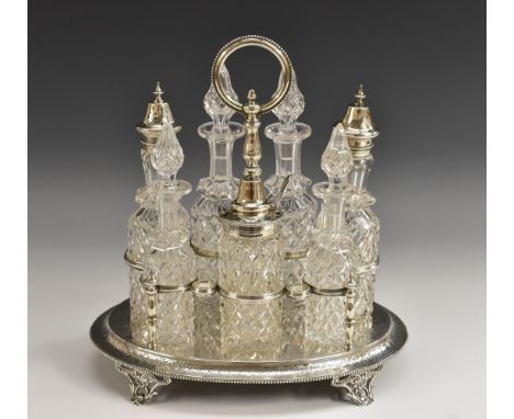 A Victorian silver seven-bottle cruet stand, engraved wit anthemions and scrolls, pierced scroll feet, posted beaded loop han