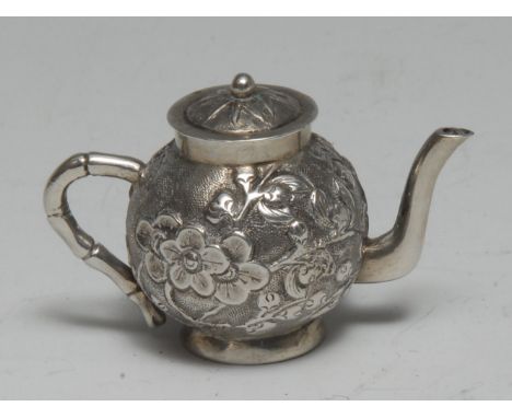 A Chinese silver miniature teapot, chased with blossoming prunus, faux bamboo handle, 4.5cm long