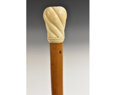 An early 18th century gentleman's ivory and malacca walking stick, globular wrythen fluted handle above a socle, slightly tap