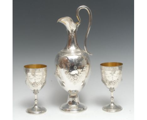 A Victorian silver three piece wine service, comprising ovoid pedestal claret ewer and a pair of goblets, chased and bright-c